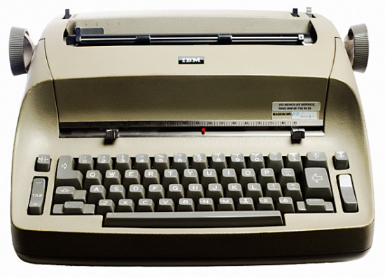 Vid sidan av skrivbordet, på ett litet rangligt bord med hjul, var IBMS elektriska skrivmaskiner vanliga på kontoren.