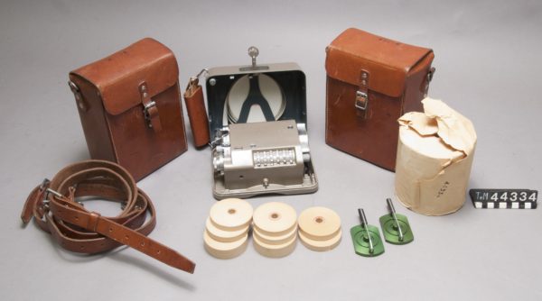 Kryptograf med pappersrullar och läderväska.